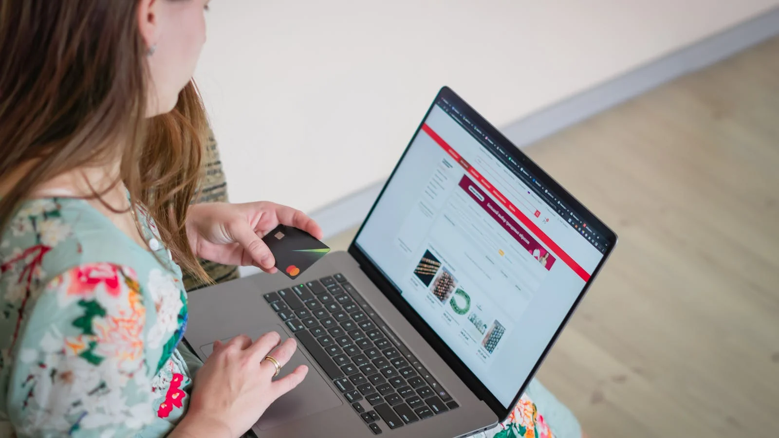 A shopper comparing products online with a laptop and credit card before visiting any brand site.