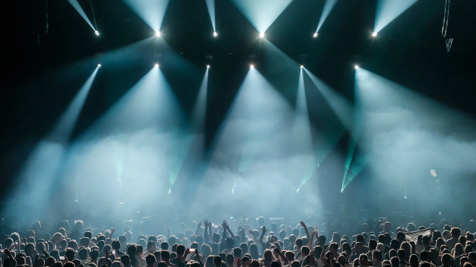 Concert crowd lit by warm stage light, the kind of audience a release press cycle is trying to build